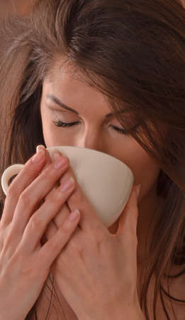Beautiful latin woman drinking tea cup after relaxing beauty treatment center.の写真素材