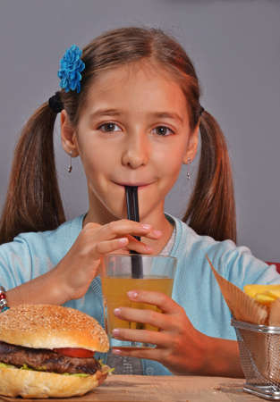 Little girl eating burgerの写真素材