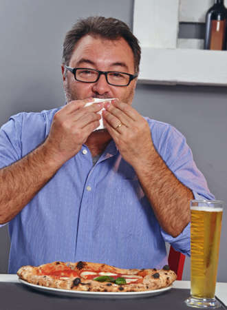 Hungry fat man eating pizzaの写真素材
