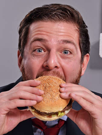 Businessman eating burgerの写真素材