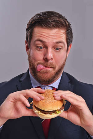 Businessman eating burgerの写真素材