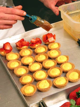 pastry cook preparing mini cup cakes at kitchen bakery