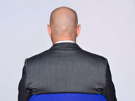 Back view from a bald head sitting on chairの写真素材