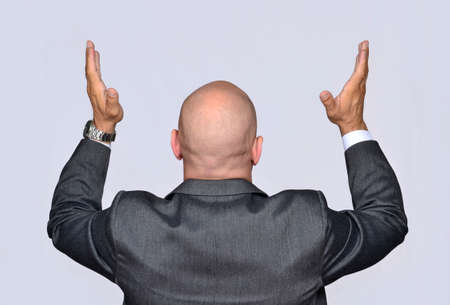 Businessman with raised hands, praying, desperate.の写真素材