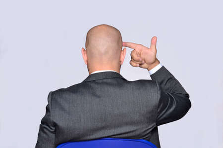 Businessman pointing hand gun on headの写真素材