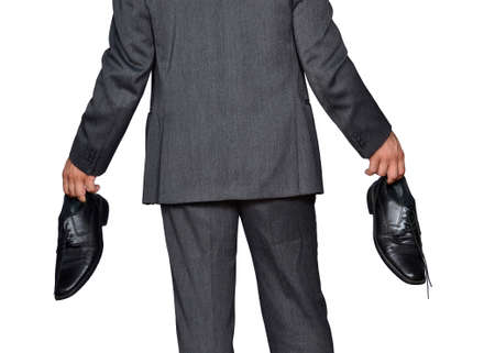 Back view from a business man holding shoes, debt concept.の写真素材