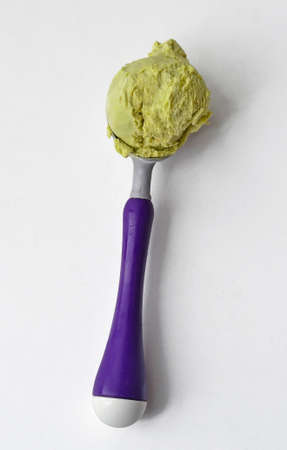 Pistachio ice cream ball on spoon isolated on white background.の写真素材