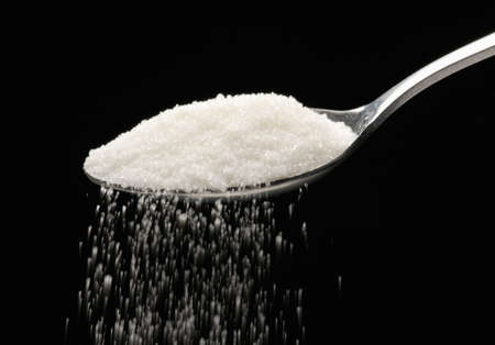 White sugar teaspoon on white background.の写真素材