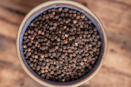 Peppercorns on wooden background