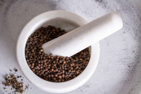 black peppercorns in mortar on ceramic backgroundの写真素材