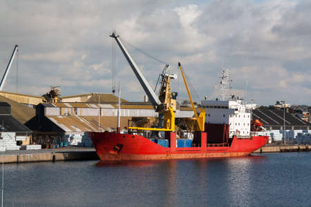 Unloading of a cargo ship at dockの写真素材