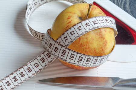 Apple, knife, scale and tape meter
