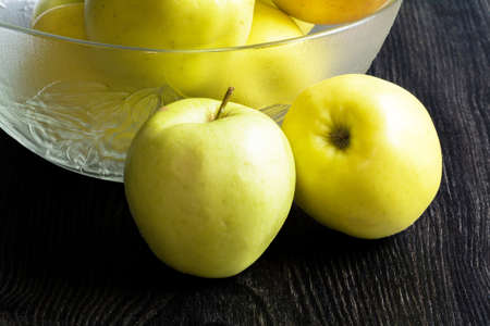 Golden apples to a bowl on a black backgroundの写真素材