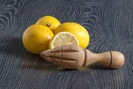 Lemons and press fruits of artisanal production in olive wood on a dark backgroundの写真素材