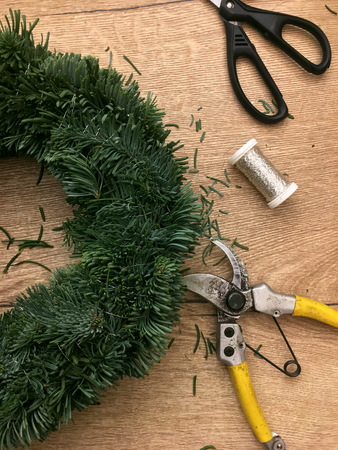 Things to manufacture Christmas wreaths on wooden table.