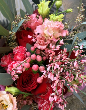 Close-up Beautiful Bouquet. Bouquet of flowers pink genista, pink Eustoma, red rose, pink hypericum berries , spray roses. Beautiful bright flowers background.の写真素材