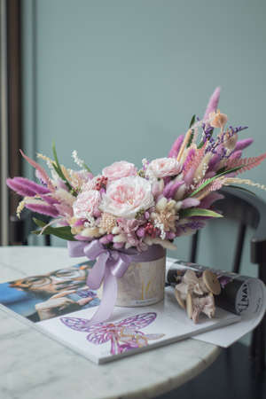Bouquet with roses, hydrangea and a and dry lagurus in pink color. Stabilized flowers in a ceramic vase at home on the dressing table. Interior decor.の写真素材