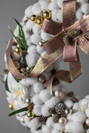 Stylish White Christmas Wreath, holiday decoration. Cotton Wreath. Christmas wreath made of cotton, golden balls, pine cones and big beautiful golden bow.の写真素材