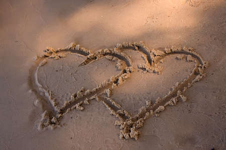 Double hearts painted on the yellow sand の写真素材
