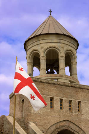 Georgian flag over orthodox monastery with blue skyの写真素材
