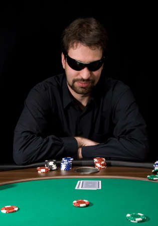 Man in black shirt plaing poker in the casino のeditorial素材