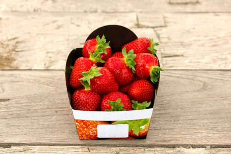 A basket of mouthwatering freshstrawberries on tableの写真素材