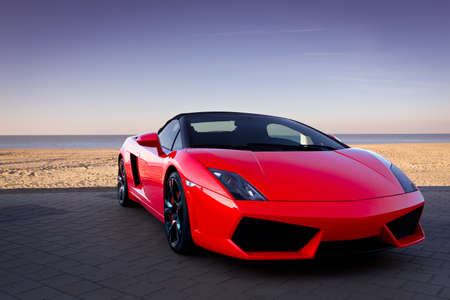 Expensive red sports car at beautiful sunset Expensive red sports car at beautiful sunset
