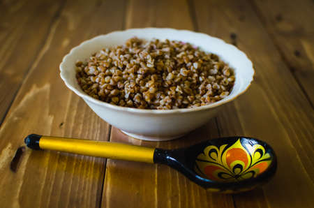 Cooked buckwheat on wooden spoon
