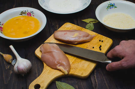 The chicken meat and the kitchen knifeの写真素材