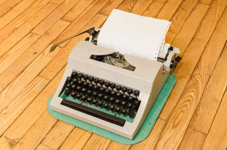 Vintage typewriter on the old wooden floorの写真素材