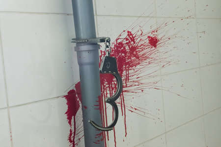 Iron handcuff on bloody wall horrorの写真素材