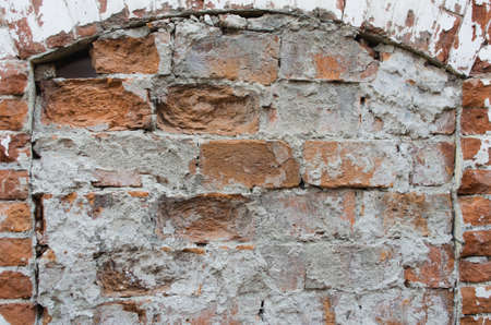 Old red brick wall with cracks and scratches. Horizontal wide brickwall background. Distressed wall with broken bricks texture. Vintage house facade.の写真素材