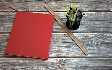 Book with red cover on wooden table against white backgroundの写真素材