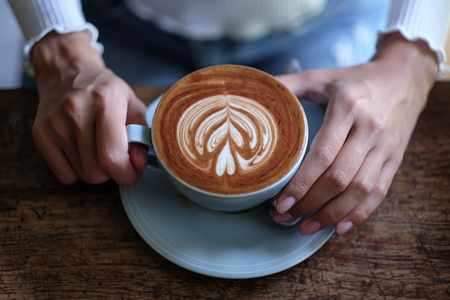 girl holding latte coffee in cafeの写真素材