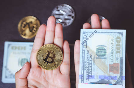 Hand holding bitcoin with trading market forex chart on computer showing growth uprising of cryptocurrency coinsの写真素材