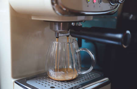 pouring hot coffee from machine for making good healthy drink in homeの写真素材