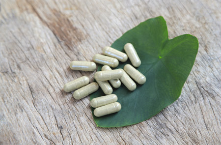 herbal powder capsules from organic herbal ingredient on green leaf for healthy eating in daily life. alternative healthy eating food supplement concept.の写真素材