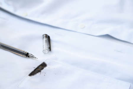 Dirty black ink stain on shirt from using in daily life. dirty stain for cleaning concept.の写真素材