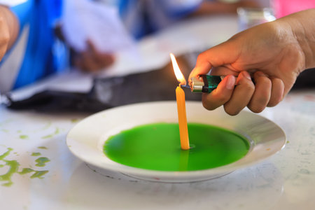 hand using fire lighter with candle in science experiment for kid activityの写真素材