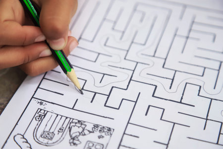 kid hand with pencil doing maze line game for learning and practise brain using in learning ideaの写真素材