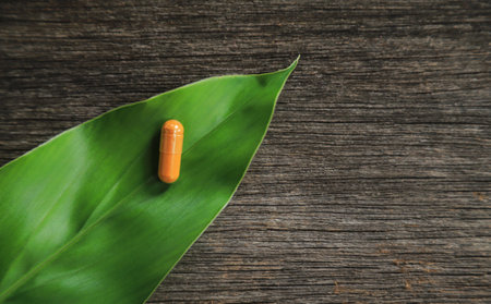 Herbal capsules from yellow tumeric on leaf for healthy eating in daily lifeの写真素材