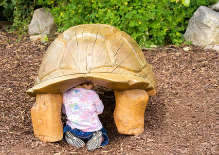 Baby hidden below statue tortoise の写真素材