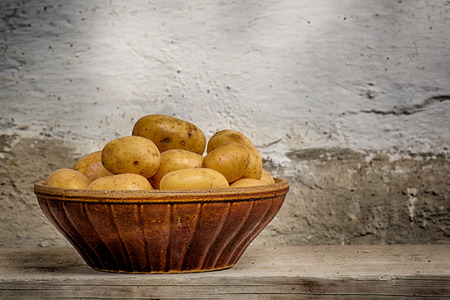 Pile of potatoes arranged on an earthenware bowl.の写真素材