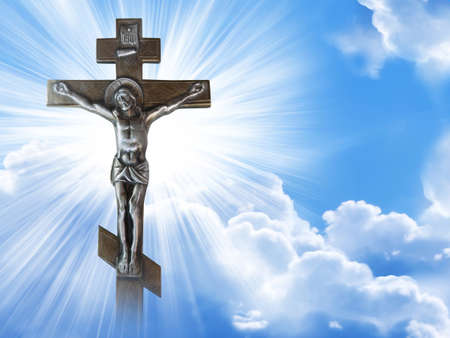 Silhouette of the crucified Jesus Christ on the cross against the blue sky.の写真素材