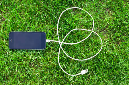 Phone detail with cable on grassの写真素材