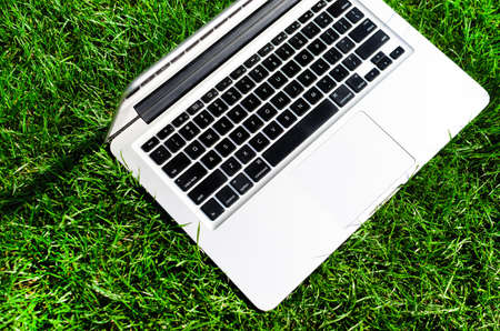 Working with laptop on freshly cut grassの写真素材