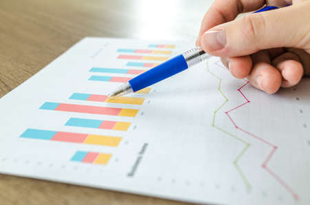Man showing business graph on wooden table