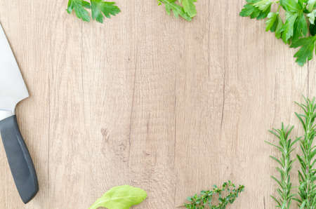 Herbs with knife on wooden tableの写真素材