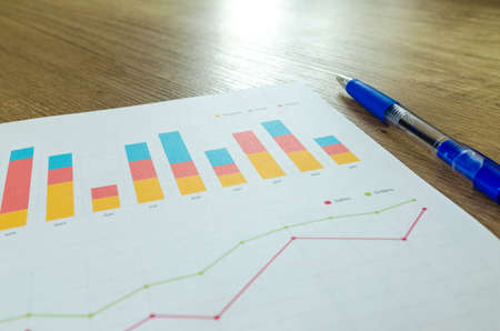 Workplace on wooden table with graph papersの写真素材