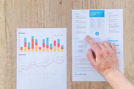 Man showing business graph on wooden tableの写真素材